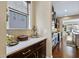 Kitchen with dark wood cabinets, light countertops, backsplash, and seamless flow into living area at 437 Creekhurst Pl, Cary, NC 27519