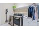 Well-lit laundry room featuring modern washer, dryer, sink and ample storage space at 437 Creekhurst Pl, Cary, NC 27519