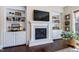 Living room featuring a fireplace, built-in shelving, hardwood floors, and lots of natural light at 437 Creekhurst Pl, Cary, NC 27519