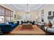 Spacious living room with hardwood floors, a chandelier, and stylish blue couches at 437 Creekhurst Pl, Cary, NC 27519