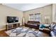 Comfortable living room with hardwood floors, a plush leather sofa, and a large tv at 437 Creekhurst Pl, Cary, NC 27519