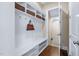 Mudroom with cubbies, storage shelves, hooks, hardwood floors, and painted white walls at 437 Creekhurst Pl, Cary, NC 27519
