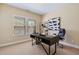 A cozy office with a modern desk, rolling chair, carpeted floors, and great natural light at 437 Creekhurst Pl, Cary, NC 27519