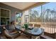 Covered porch featuring an inviting table with seating and views of a tranquil wooded area at 437 Creekhurst Pl, Cary, NC 27519