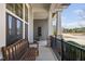 Relaxing front porch with a wooden bench, stone pillars, and black railing at 437 Creekhurst Pl, Cary, NC 27519