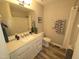 Well-lit bathroom with a vanity, toilet, and combination shower and tub at 46 Grain Ln, Henderson, NC 27537