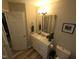 Bathroom features a vanity with quartz countertop, large mirror and tiled floors at 46 Grain Ln, Henderson, NC 27537