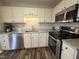 Updated kitchen with stainless steel appliances, granite countertops, white cabinets, and wood flooring at 46 Grain Ln, Henderson, NC 27537