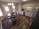 Bright kitchen featuring stainless appliances, granite countertops, and wood flooring open to dining area at 46 Grain Ln, Henderson, NC 27537
