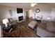 Cozy living room with a fireplace, ceiling fan, wood flooring, and comfortable seating, perfect for relaxation at 46 Grain Ln, Henderson, NC 27537