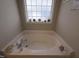Bright tub is surrounded by decor at 46 Grain Ln, Henderson, NC 27537