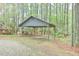 Carport with open-air design, providing shaded parking surrounded by trees and greenery at 505 Marion Way, Chapel Hill, NC 27516