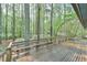 A large wooden deck featuring benches overlooks a peaceful wooded area at 505 Marion Way, Chapel Hill, NC 27516
