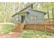 Charming gray home featuring a covered porch and wooden steps leading to the front door, surrounded by nature at 505 Marion Way, Chapel Hill, NC 27516