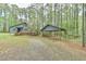 Exterior of home with gravel driveway and carport surrounded by green lawn and mature trees at 505 Marion Way, Chapel Hill, NC 27516