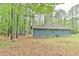 Home exterior highlighting the side of the home, nestled in a wooded area with a carport at 505 Marion Way, Chapel Hill, NC 27516