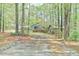 View of a cozy home and carport nestled among tall trees, creating a serene setting at 505 Marion Way, Chapel Hill, NC 27516