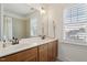 Bathroom vanity with double sinks, framed mirror and window with plantation shutters at 528 Clifton Blue St, Wake Forest, NC 27587