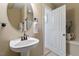 This bathroom features a pedestal sink, a framed mirror, and a white door at 528 Clifton Blue St, Wake Forest, NC 27587