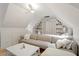 Comfortable bonus room features sloped ceilings, built in shelving, and neutral colored furniture at 528 Clifton Blue St, Wake Forest, NC 27587