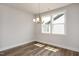 Cozy dining area with a modern chandelier, wood floors, and natural light from the window at 520 Folk Song Way, Wendell, NC 27591