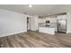 Open-concept layout of the living room and kitchen with wood flooring and ample natural light at 520 Folk Song Way, Wendell, NC 27591