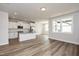Bright and airy living area featuring wood floors and large windows with a view of the kitchen and dining area at 520 Folk Song Way, Wendell, NC 27591