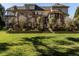 Large landscaped backyard with stone terraces leading to the grand home with screened porch at 5768 Cavanaugh Dr, Raleigh, NC 27614