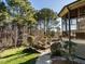 Spacious backyard showcasing stone terrace adjacent to screened in porch surrounded by mature landscaping and trees at 5768 Cavanaugh Dr, Raleigh, NC 27614