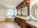 Luxurious primary bathroom with a large soaking tub, dual vanities, and granite countertops at 5768 Cavanaugh Dr, Raleigh, NC 27614
