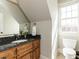 Well-lit bathroom featuring granite countertop, modern fixtures, vanity, toilet, and window at 5768 Cavanaugh Dr, Raleigh, NC 27614