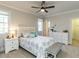 Bright bedroom with a bed, two windows, two nightstands and dressers, ceiling fan, and ensuite bathroom at 5768 Cavanaugh Dr, Raleigh, NC 27614