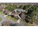 Exterior shot of a grand home with a circular driveway, mature trees, and professionally landscaped grounds at 5768 Cavanaugh Dr, Raleigh, NC 27614