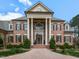 Close up of a beautiful brick home showcasing grand columns and meticulously maintained landscaping at 5768 Cavanaugh Dr, Raleigh, NC 27614