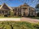 Stately brick home showcasing grand entrance, meticulously landscaped front yard, and circular driveway at 5768 Cavanaugh Dr, Raleigh, NC 27614
