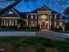 Elegant brick home at dusk with dramatic lighting accentuating architectural details and manicured landscaping at 5768 Cavanaugh Dr, Raleigh, NC 27614