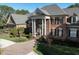 Stately brick home featuring a grand columned entryway, mature landscaping, and a brick driveway at 5768 Cavanaugh Dr, Raleigh, NC 27614