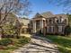 Stunning brick home featuring a circular driveway, lush landscaping, and architectural details at 5768 Cavanaugh Dr, Raleigh, NC 27614