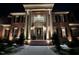 Elegant brick home with classic architectural details and manicured landscaping at night at 5768 Cavanaugh Dr, Raleigh, NC 27614