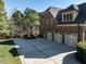 Brick home featuring an extra wide driveway leading to a three car garage and beautifully landscaped front yard at 5768 Cavanaugh Dr, Raleigh, NC 27614