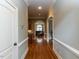 Hallway with hardwood floors leading to a well-lit living space at 5768 Cavanaugh Dr, Raleigh, NC 27614