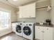 Well-lit laundry room includes washer, dryer, custom cabinetry, counter space and large window at 5768 Cavanaugh Dr, Raleigh, NC 27614