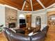 Spacious living room with stone fireplace, wood ceiling, and a large leather sectional at 5768 Cavanaugh Dr, Raleigh, NC 27614