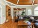 Open-concept living room with wood ceilings, hardwood floors, built-in shelving, and large windows at 5768 Cavanaugh Dr, Raleigh, NC 27614