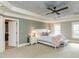 Relaxing main bedroom showcasing trey ceiling, ceiling fan, plush carpet and ensuite bathroom at 5768 Cavanaugh Dr, Raleigh, NC 27614
