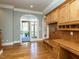 Spacious mudroom with built-in bench, desk, cabinets, and arched doorway to the screened-in porch at 5768 Cavanaugh Dr, Raleigh, NC 27614