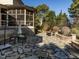 Expansive backyard stone patio features an outdoor dining area, screened porch, and mature trees at 5768 Cavanaugh Dr, Raleigh, NC 27614