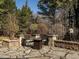 Stone patio with outdoor seating area and fire pit surrounded by lush landscaping, perfect for entertaining at 5768 Cavanaugh Dr, Raleigh, NC 27614