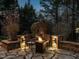 Cozy stone patio at twilight featuring a fire pit, comfortable seating, and ambient lighting at 5768 Cavanaugh Dr, Raleigh, NC 27614