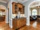 A wood wet bar features a sink and granite countertop, located between the living room and kitchen at 5768 Cavanaugh Dr, Raleigh, NC 27614